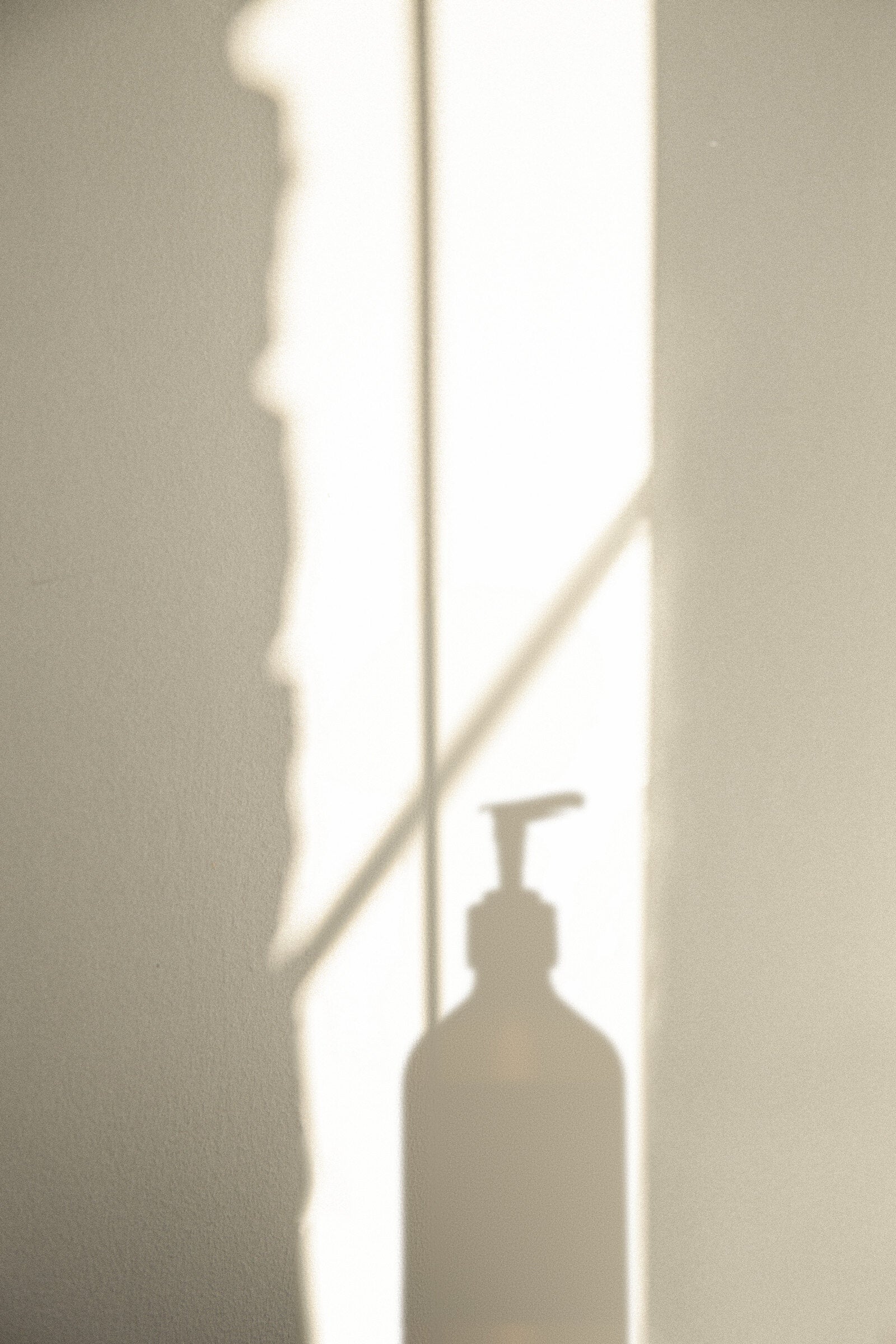 A Hytti 490 ml bottle with the shadow of flowers on the wall behind