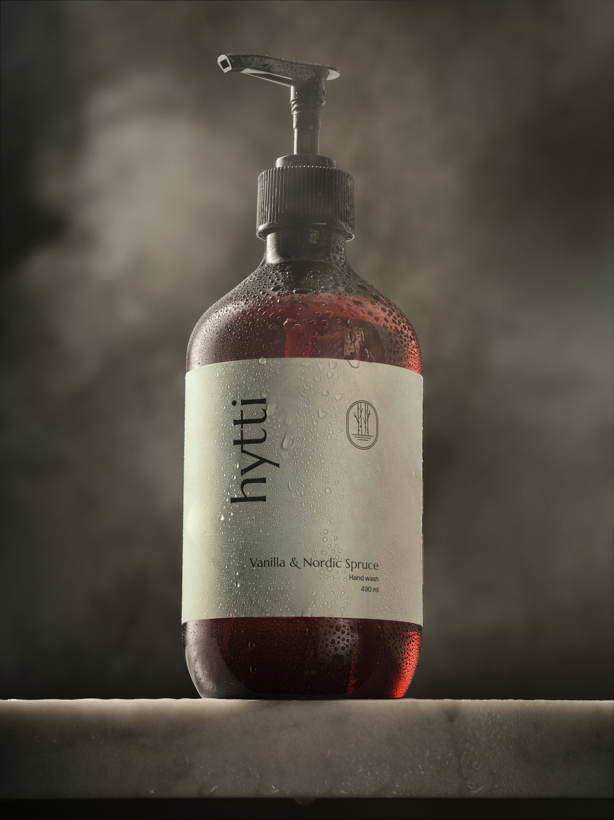 A Hytti 490 ml bottle on a wooden sauna ledge in steam, beaded with water