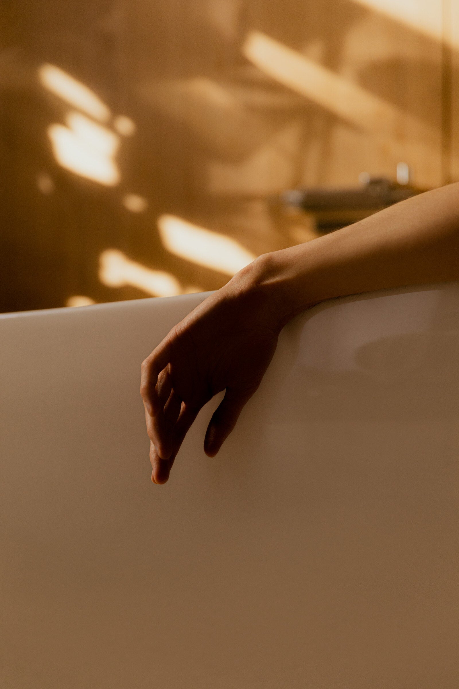 A hand resting on the edge of a bath